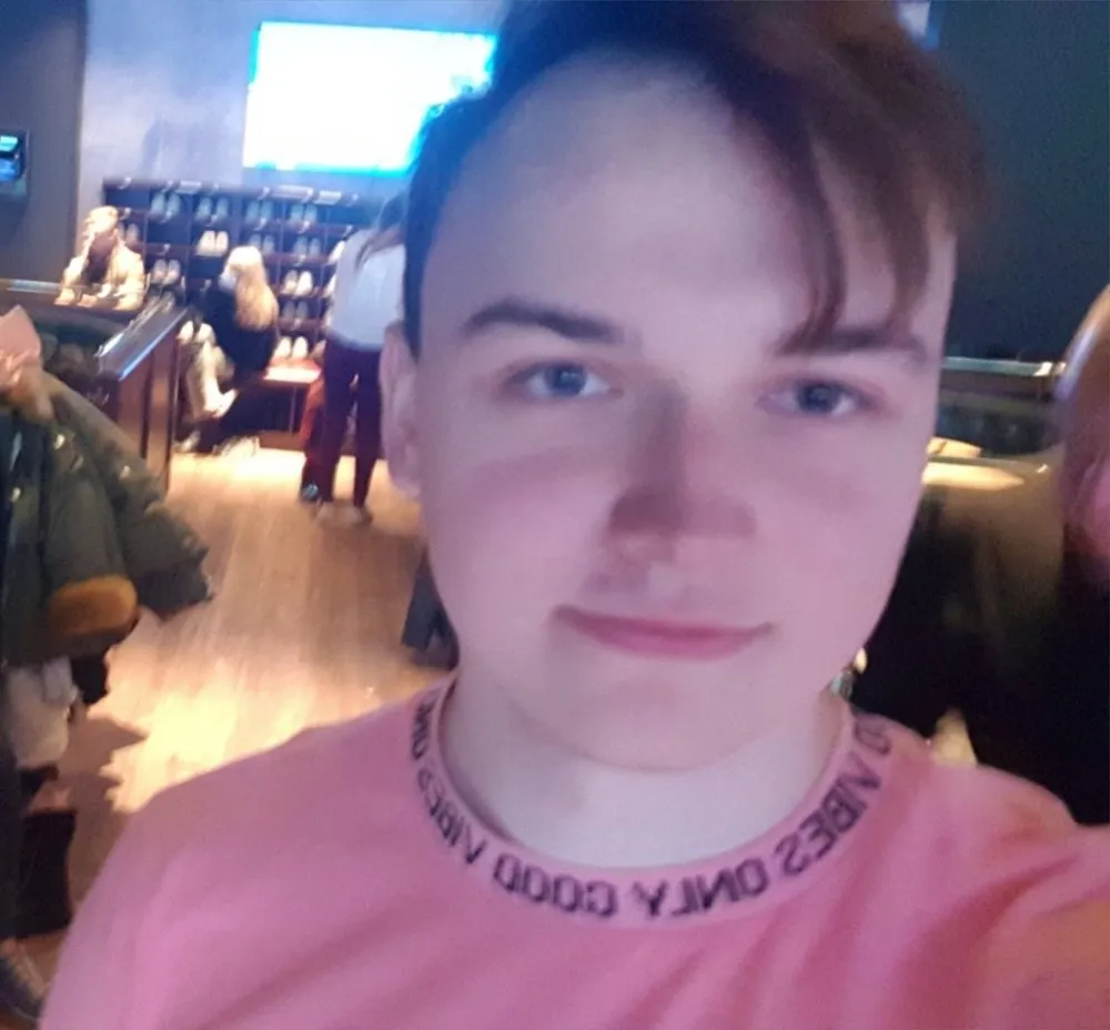 Selfie of Yuozas at a bowling alley, wearing a shirt whose collar reads good vibes only