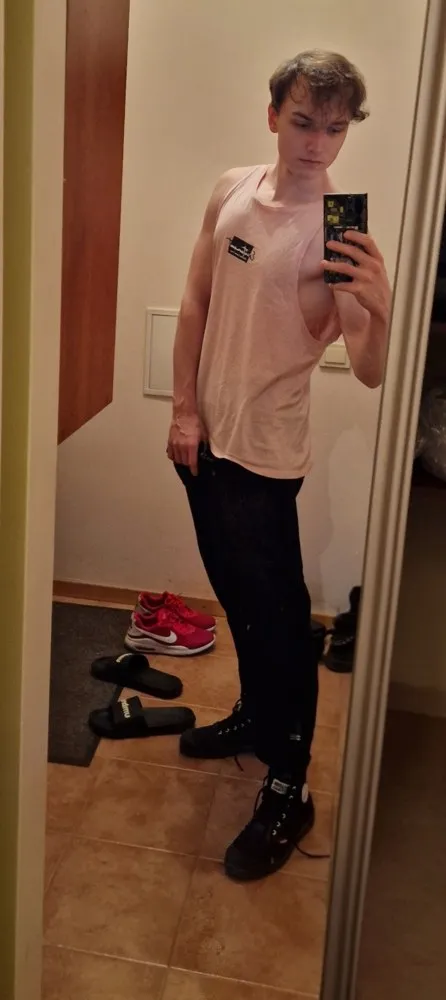 Mirror photo of Yuozas right now — pink tank top, phone in hand